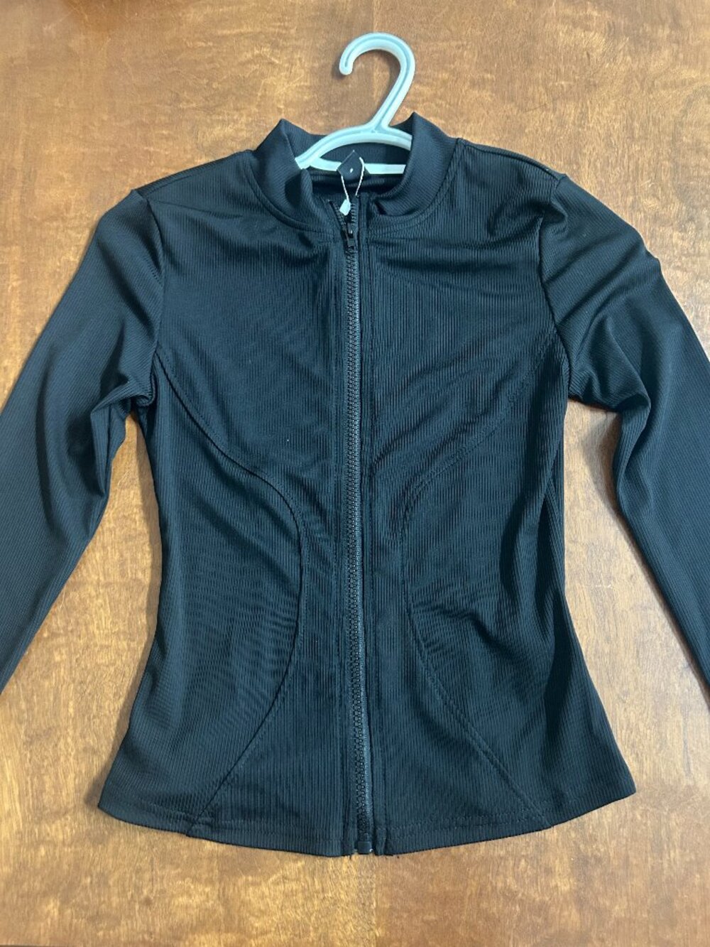 Black formfitting zip-up workout jacket